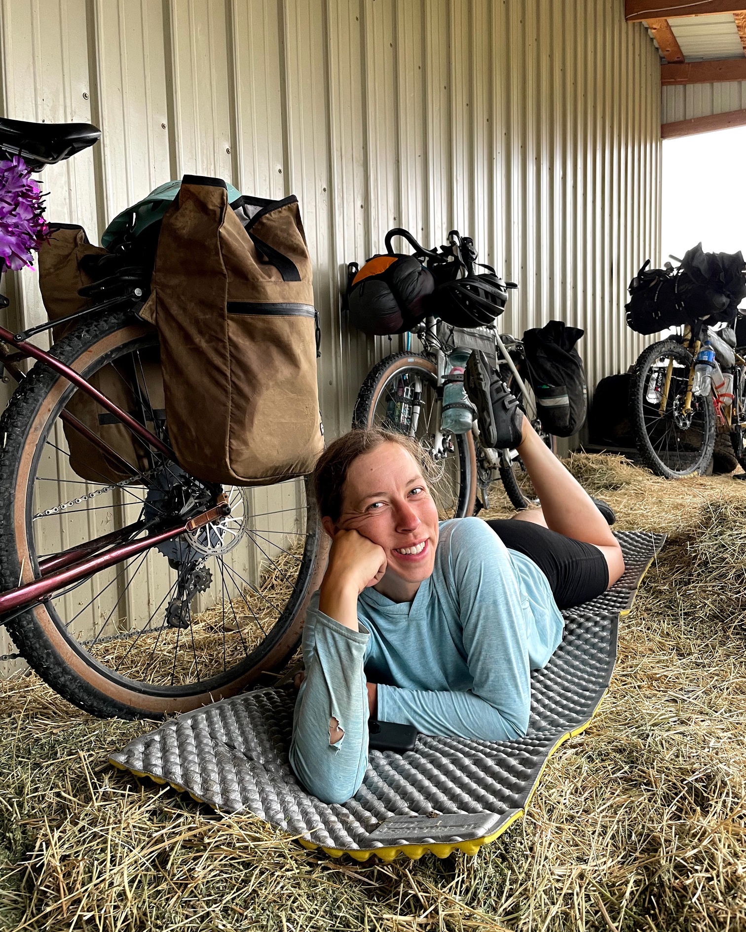 Alyssa Hursh lounging on a Thermarest z-lite sleeping pad in a hay barn