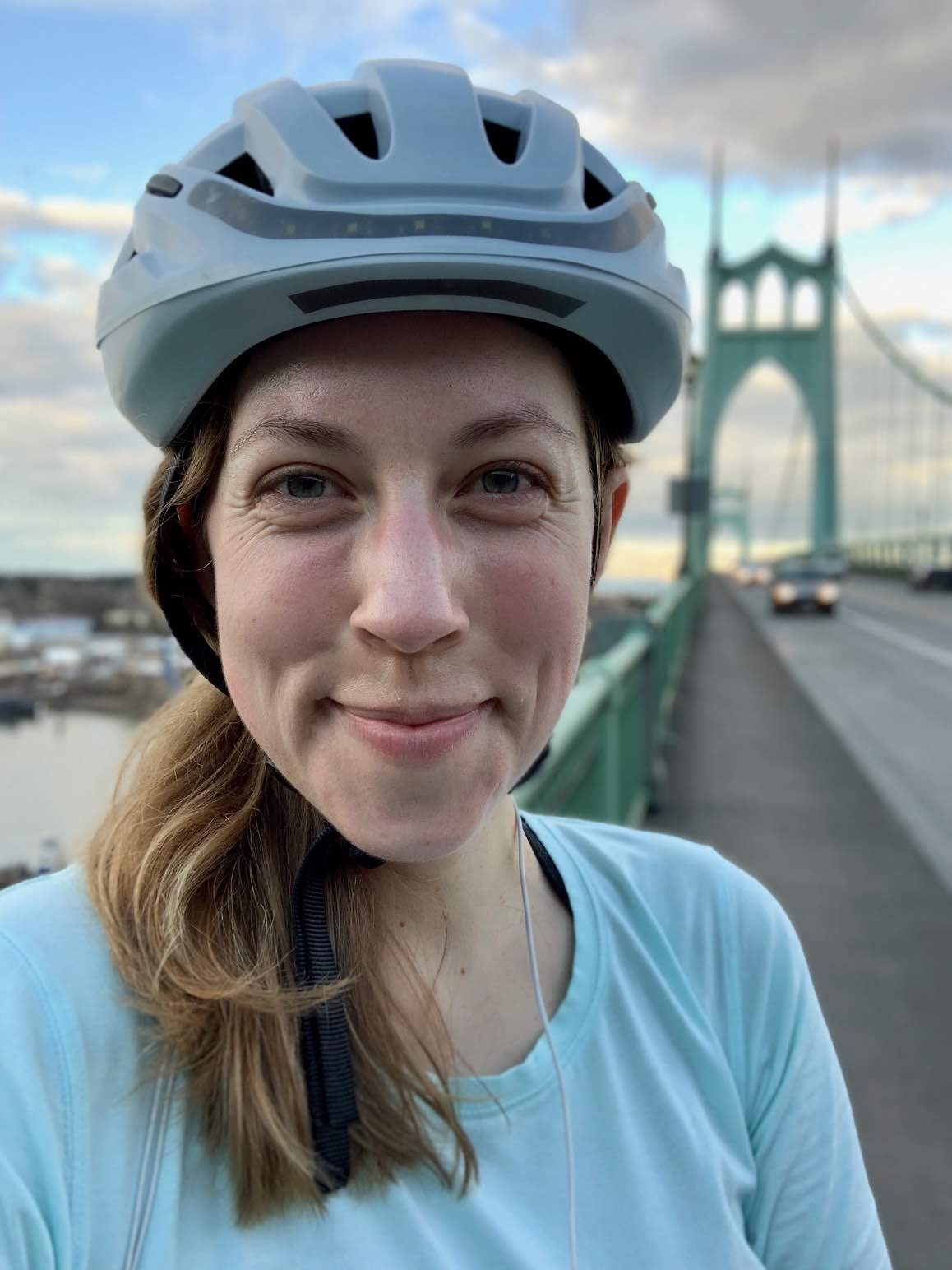 Portrait of Alyssa Hursh in a bike helmet on the St John's Bridge in Portland, Oregon